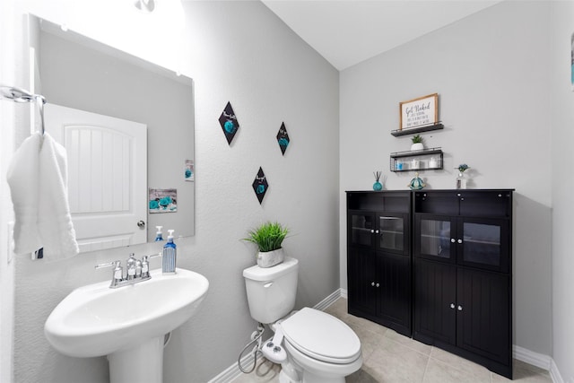 bathroom featuring toilet, tile patterned flooring, and sink