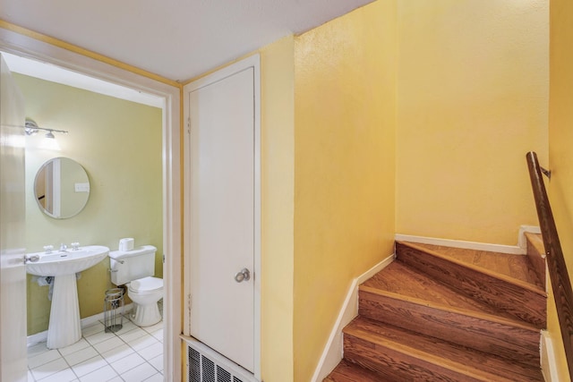 interior space with tile patterned flooring, visible vents, toilet, and baseboards