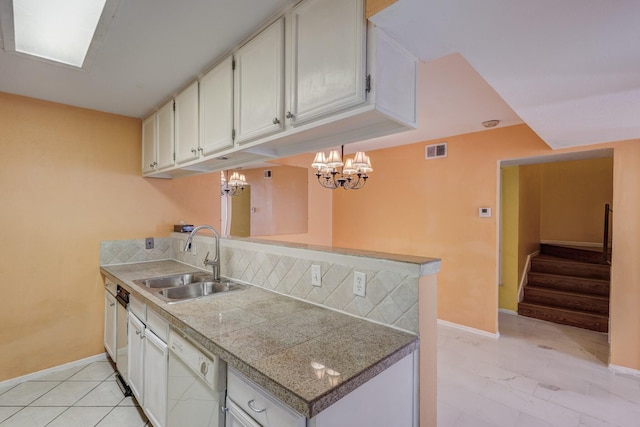 kitchen featuring dishwasher, tile countertops, white cabinetry, pendant lighting, and a sink