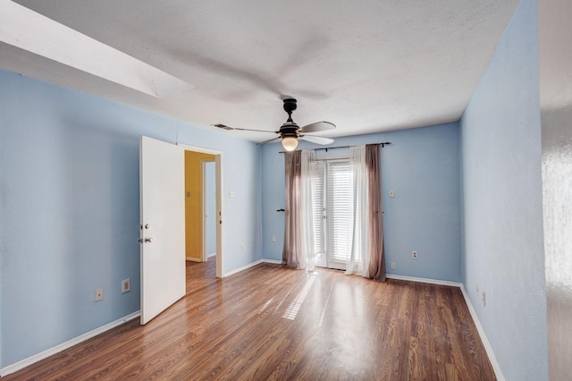 spare room with visible vents, ceiling fan, baseboards, and wood finished floors