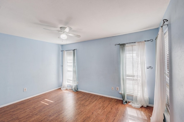 empty room featuring ceiling fan, wood finished floors, and baseboards