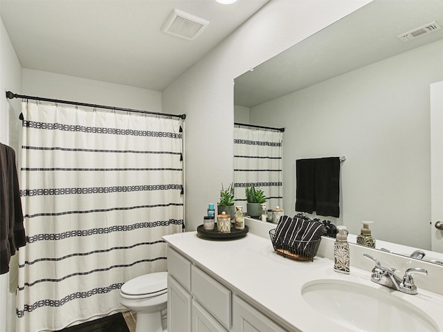 bathroom with vanity, curtained shower, and toilet