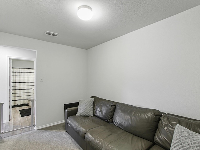 living room featuring light colored carpet and a textured ceiling