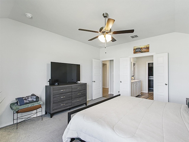 carpeted bedroom featuring connected bathroom, vaulted ceiling, and ceiling fan