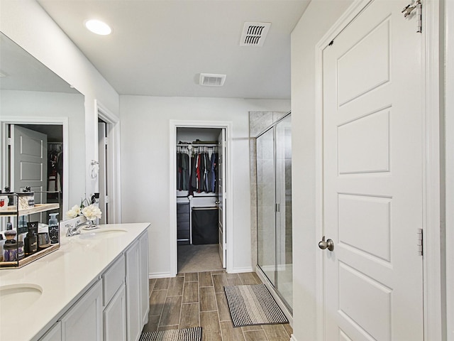 bathroom featuring vanity and a shower with door