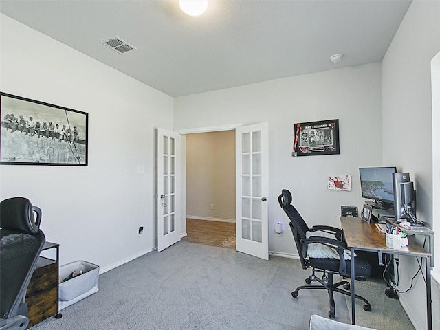 office with french doors and carpet floors