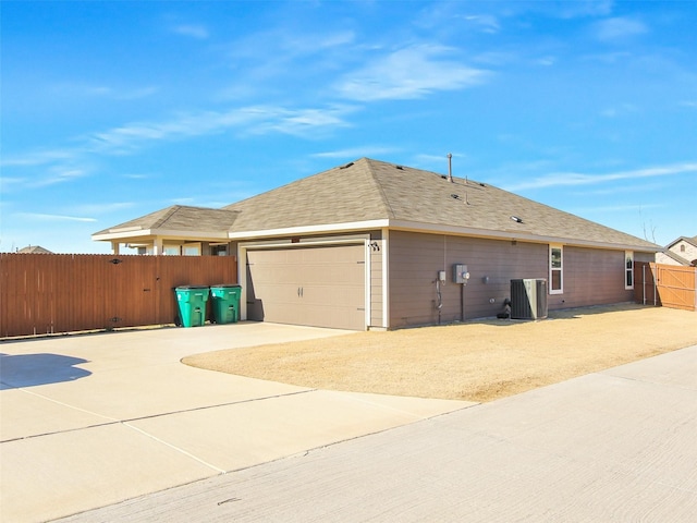 view of property exterior with a garage and central AC