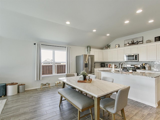 dining space featuring vaulted ceiling