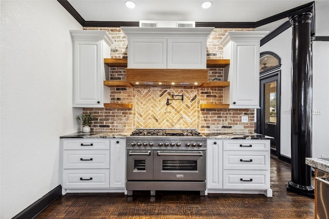 kitchen with dark stone countertops, double oven range, and white cabinetry