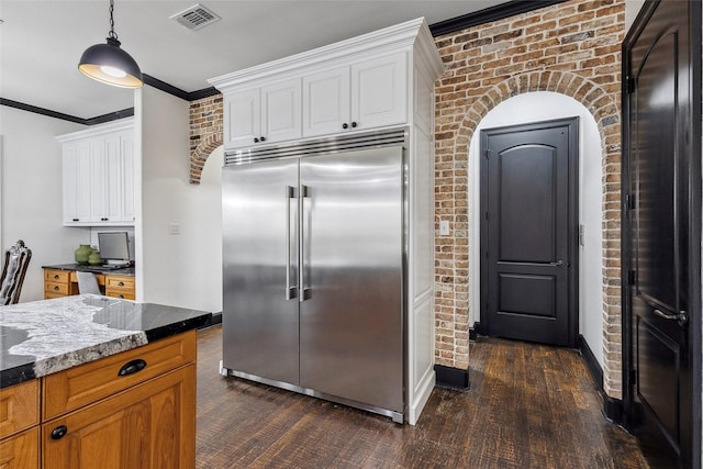 17729 Southpoint Rd, Whitehouse, TX 75791 - kitchen with stainless steel built in fridge, dark stone counters, brick wall, dark wood-type flooring, and white cabinetry