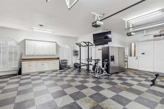 garage with a garage door opener and stainless steel fridge