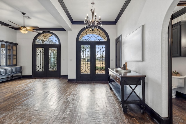 foyer entrance featuring crown molding, dark wood-type flooring, french doors, and ceiling fan with notable chandelier