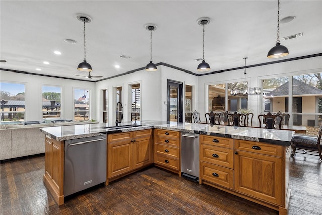 kitchen featuring sink, stainless steel dishwasher, light stone counters, and decorative light fixtures