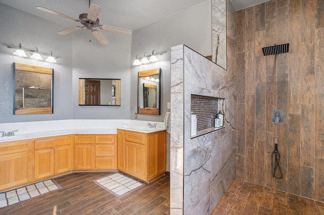 bathroom featuring a sink, double vanity, wood finished floors, and walk in shower