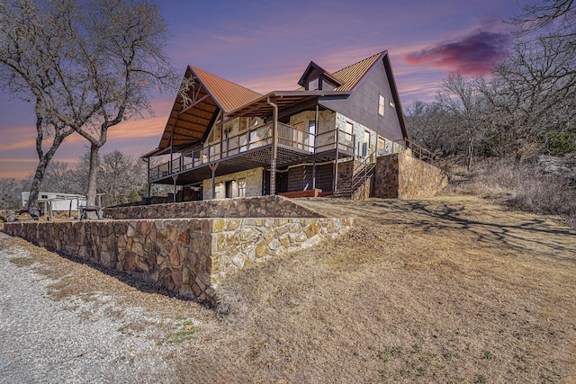 view of front of property featuring stone siding and metal roof