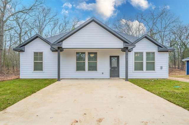 ranch-style home featuring a front lawn and covered porch