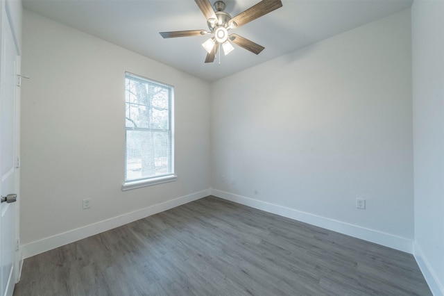 spare room featuring dark wood-type flooring and ceiling fan