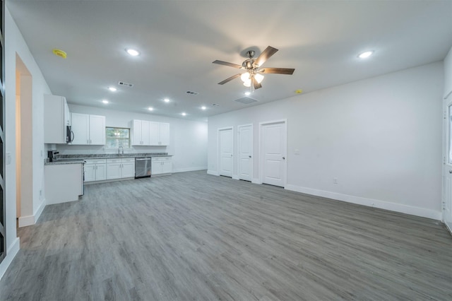 unfurnished living room with wine cooler, ceiling fan, and light wood-type flooring