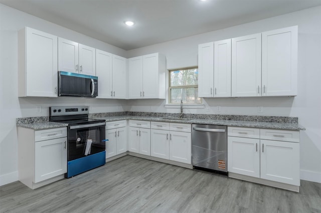 kitchen with electric range oven, sink, white cabinets, and dishwasher