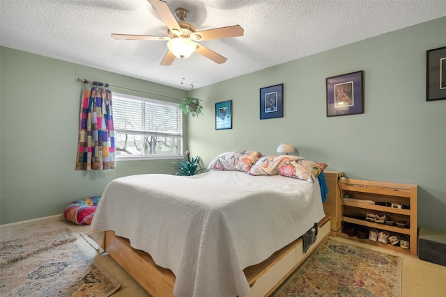 carpeted bedroom featuring ceiling fan and a textured ceiling