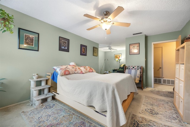 bedroom featuring ceiling fan, light colored carpet, and a textured ceiling