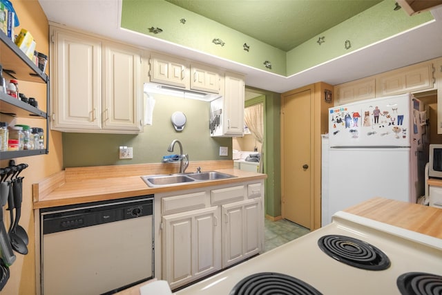 kitchen featuring white appliances, washer / dryer, sink, and butcher block countertops