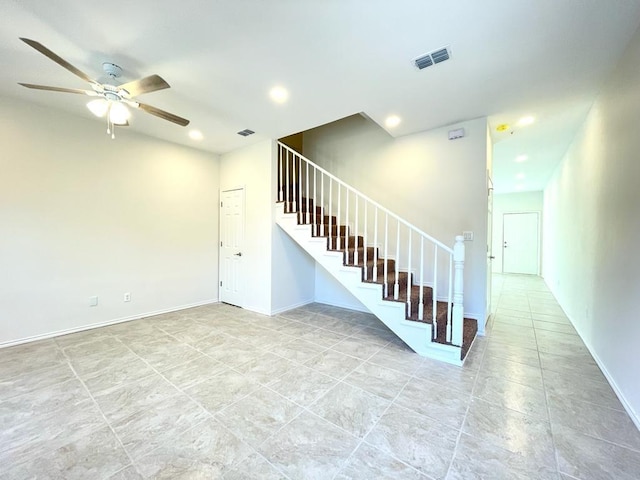 stairway featuring ceiling fan