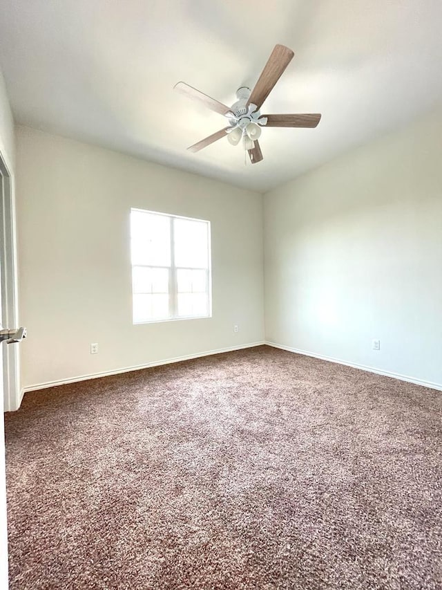 spare room featuring ceiling fan and carpet