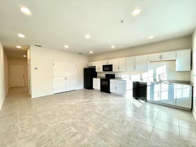 kitchen featuring white cabinetry, sink, and black appliances