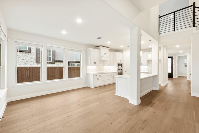 kitchen with light hardwood / wood-style floors, cooktop, and white cabinets