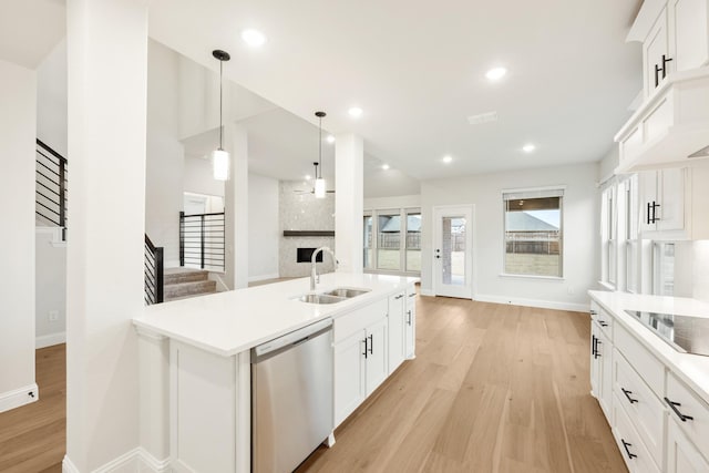 kitchen featuring dishwasher, sink, white cabinets, hanging light fixtures, and black electric cooktop