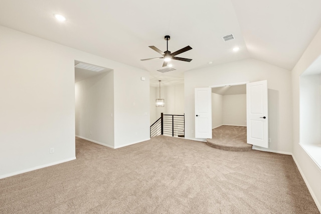 carpeted spare room featuring vaulted ceiling and ceiling fan