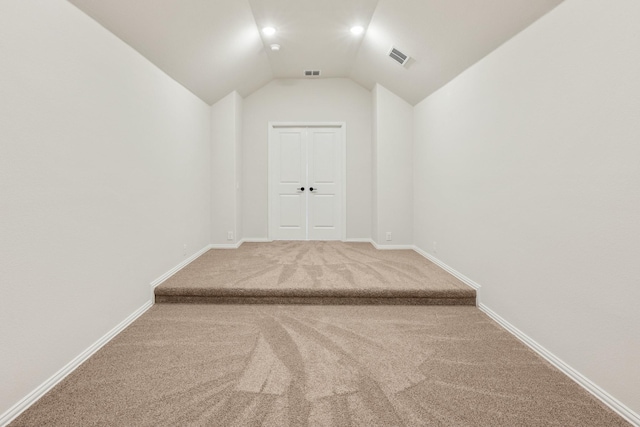 corridor with carpet and lofted ceiling