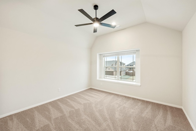 carpeted empty room featuring vaulted ceiling and ceiling fan