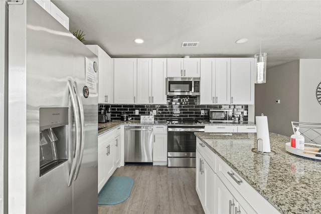 kitchen featuring pendant lighting, white cabinetry, and appliances with stainless steel finishes