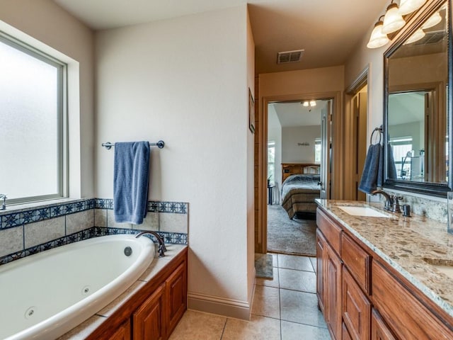 bathroom with an inviting chandelier, vanity, tile patterned flooring, and a washtub