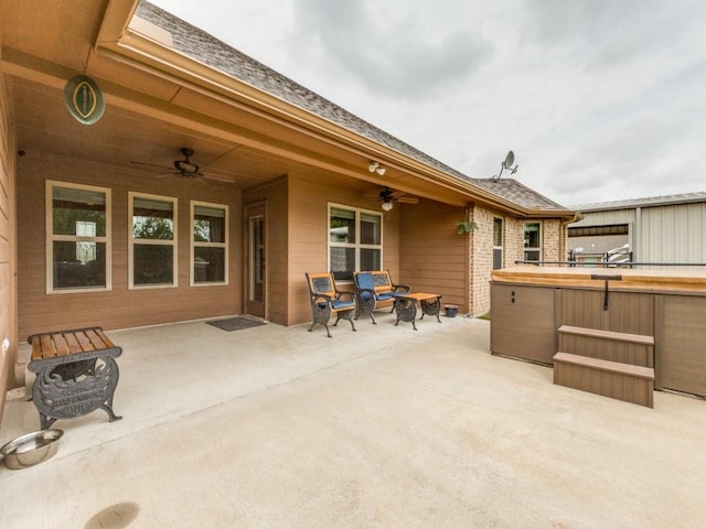 view of patio / terrace with ceiling fan and a hot tub