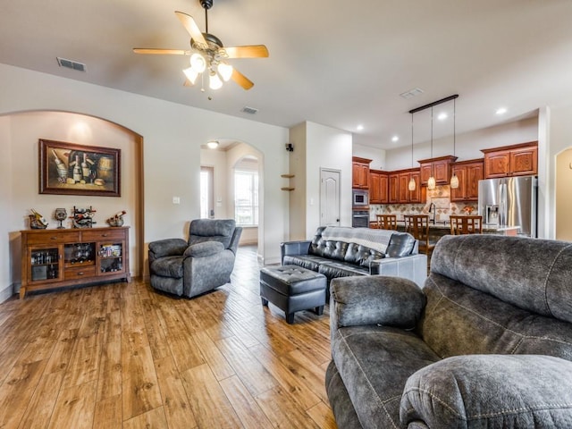 living room with ceiling fan and light wood-type flooring