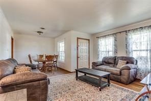 living room featuring ornamental molding, a wealth of natural light, and light hardwood / wood-style floors