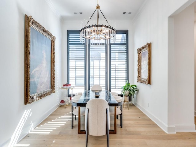 dining area with a healthy amount of sunlight, light hardwood / wood-style floors, and a notable chandelier