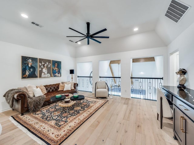 living room with vaulted ceiling, ceiling fan, and light hardwood / wood-style floors