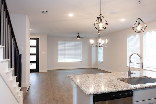 kitchen with dishwasher, sink, pendant lighting, and a kitchen island with sink