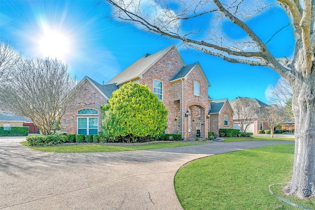 7405 Sugarbush Dr, Garland, TX 75044 - traditional-style house with brick siding, a front yard, and driveway