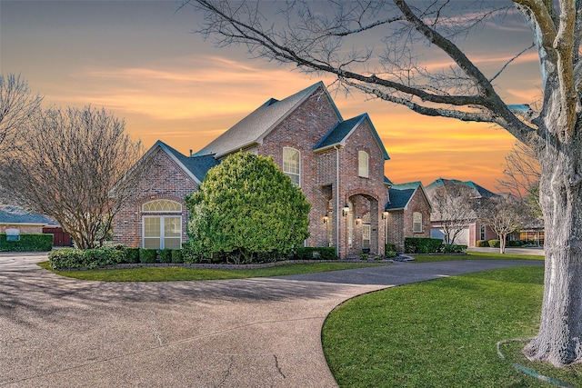 7405 Sugarbush Dr, Garland, TX 75044 - view of front of house with brick siding, curved driveway, a lawn, and roof with shingles