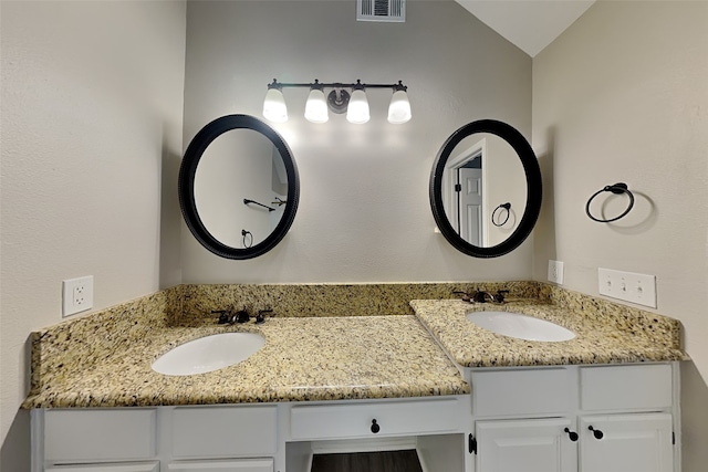 bathroom with vanity and lofted ceiling