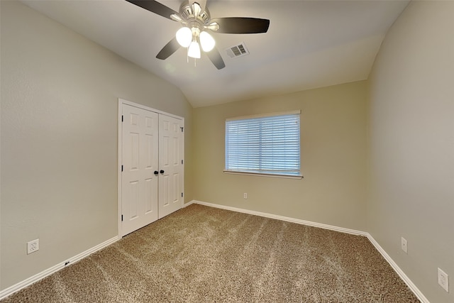 carpeted empty room with ceiling fan and vaulted ceiling