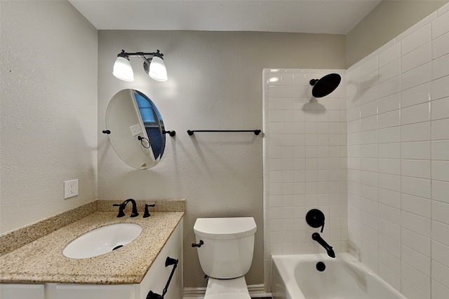 full bathroom featuring tiled shower / bath, vanity, and toilet