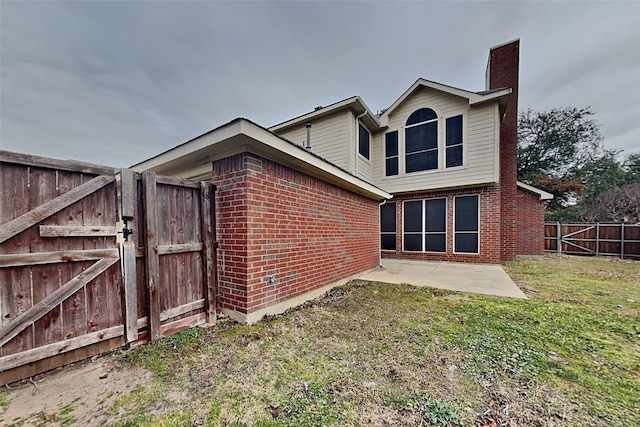 back of property featuring a lawn and a patio area