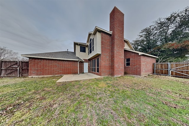 back of property with a yard and a patio area