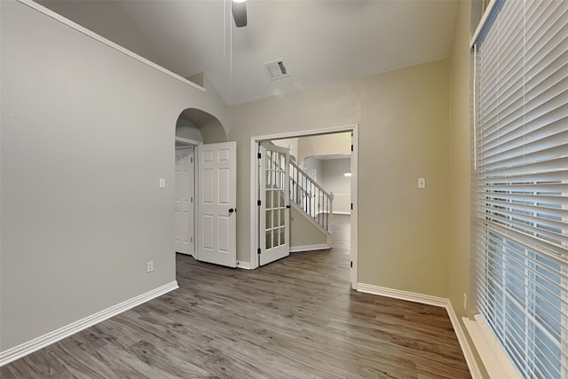 spare room with wood-type flooring, high vaulted ceiling, and ceiling fan